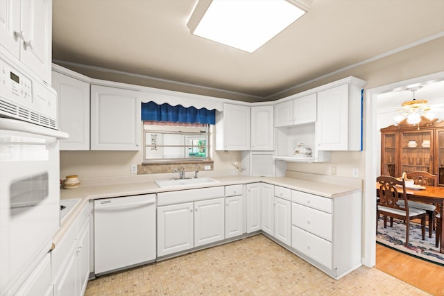 kitchen with white cabinetry, sink, light hardwood / wood-style floors, and white appliances