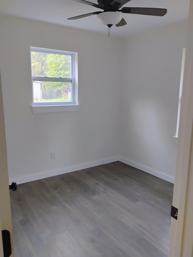 spare room with baseboards, wood finished floors, and a ceiling fan