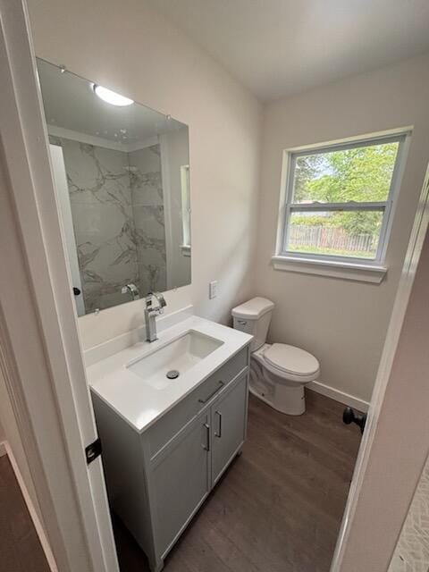 full bath with toilet, wood finished floors, and vanity