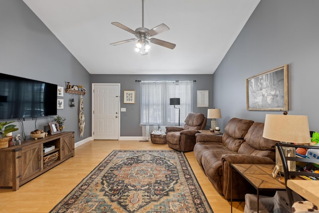 living room with light wood finished floors, baseboards, high vaulted ceiling, and ceiling fan