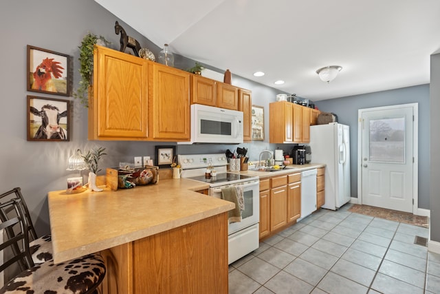 kitchen with light countertops, a sink, a peninsula, light tile patterned floors, and white appliances