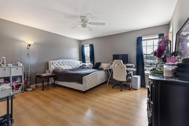 bedroom featuring multiple windows, light wood-style floors, and ceiling fan