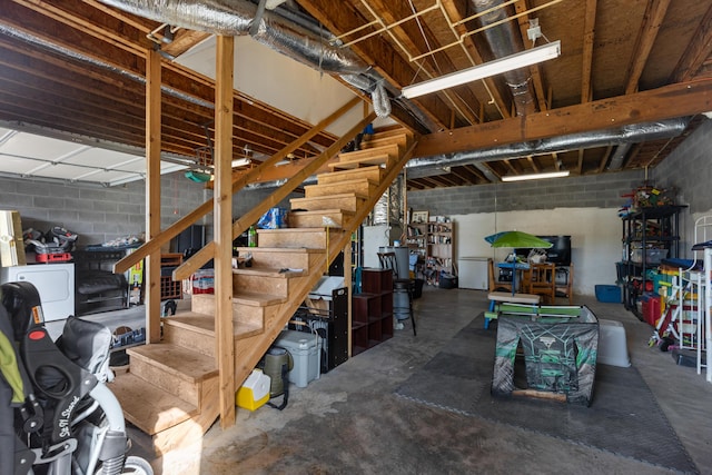 basement featuring concrete block wall and stairs