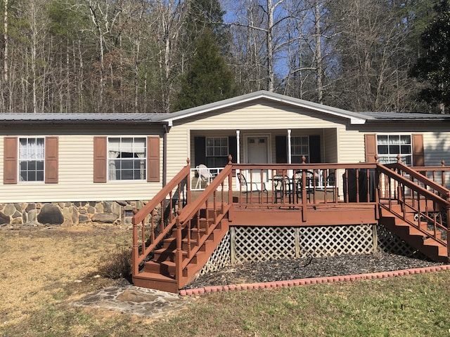 manufactured / mobile home with covered porch, metal roof, and stairs