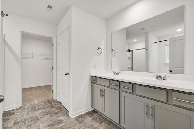 6026 Pearson Ln NW Unit 31, Cleveland, TN 37312 - bathroom featuring double vanity, a shower with door, baseboards, and a spacious closet