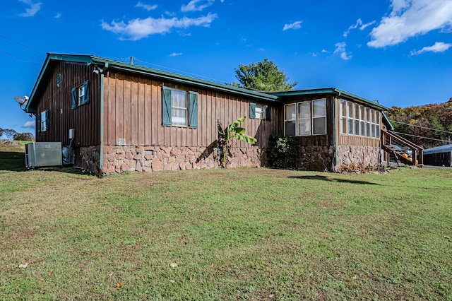 view of side of home with a lawn and cooling unit