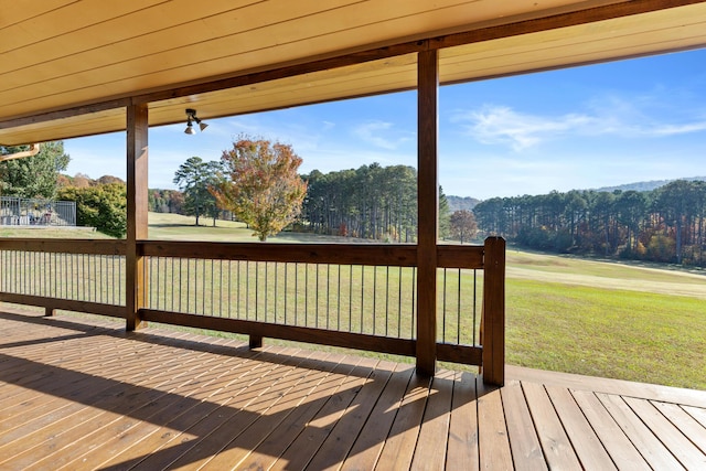 deck with a mountain view and a lawn