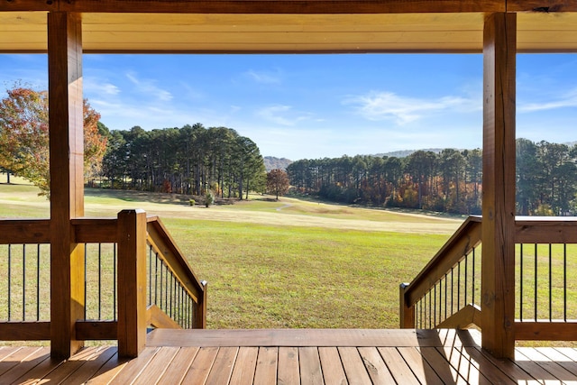 wooden terrace featuring a yard and a mountain view