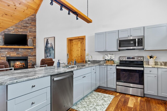 kitchen featuring high vaulted ceiling, appliances with stainless steel finishes, wooden ceiling, a sink, and gray cabinetry