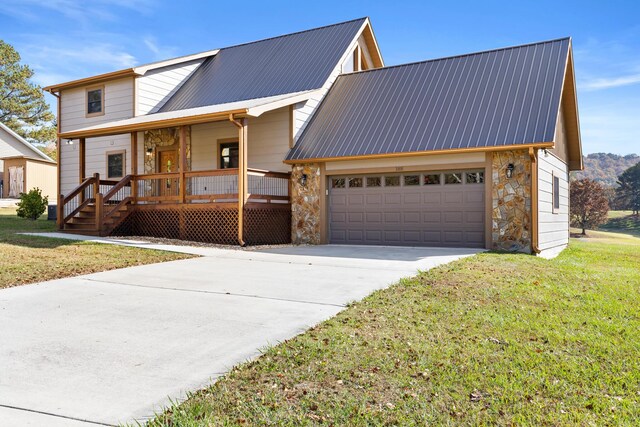 view of front of house featuring a garage, a porch, metal roof, stone siding, and driveway