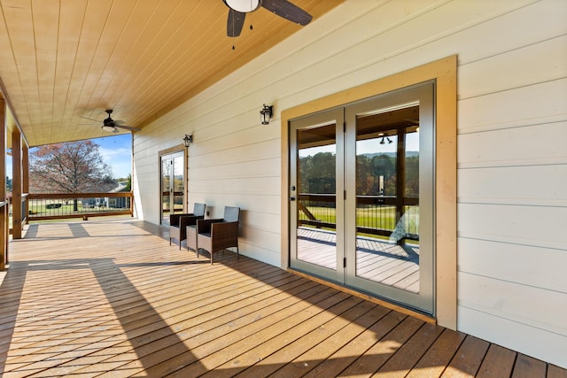 wooden terrace featuring french doors and a ceiling fan
