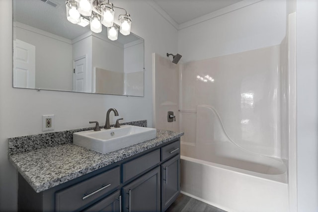full bath with an inviting chandelier, ornamental molding, wood finished floors, vanity, and bathtub / shower combination