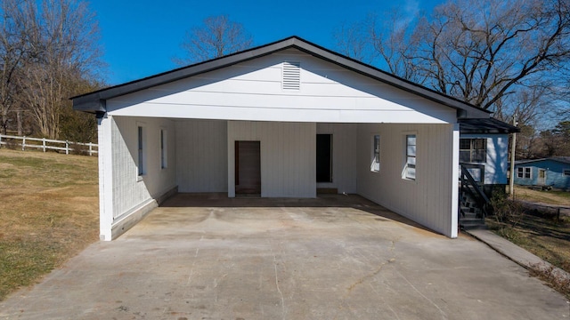 view of front facade featuring a front yard, a carport, driveway, and fence