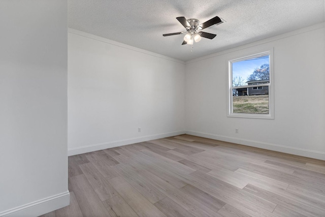 unfurnished room with a textured ceiling, ceiling fan, light wood-style flooring, and baseboards