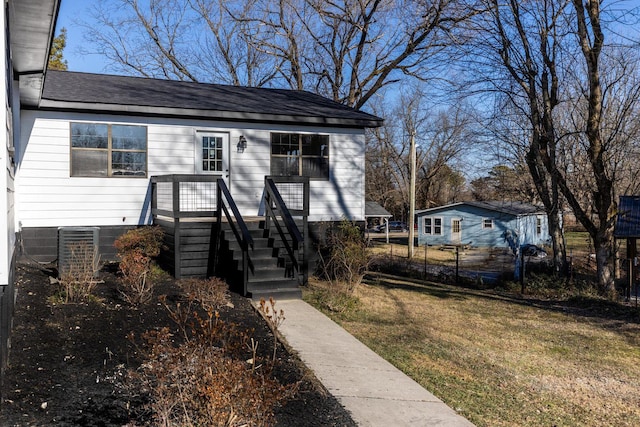 view of front of house with fence, a front yard, and central air condition unit