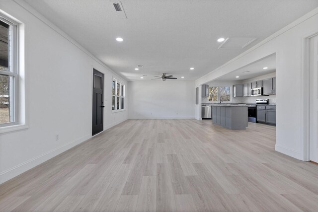 unfurnished living room featuring light wood-style floors, recessed lighting, a ceiling fan, and baseboards