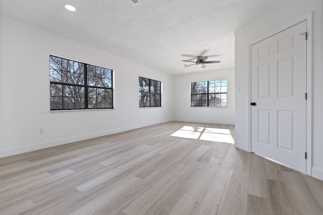 unfurnished bedroom featuring a textured ceiling, ceiling fan, light wood-type flooring, and baseboards
