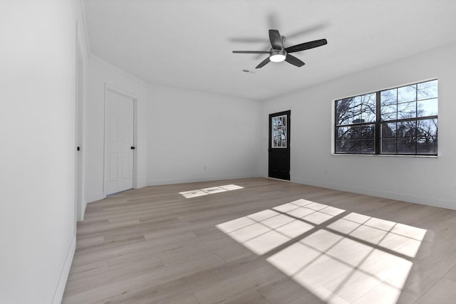 spare room with a ceiling fan, visible vents, light wood-style flooring, and baseboards