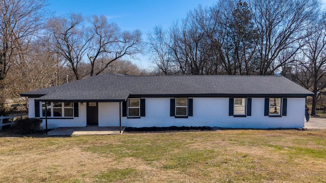 single story home with roof with shingles, a front yard, and brick siding
