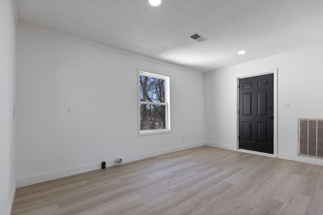 unfurnished room featuring crown molding, light wood finished floors, recessed lighting, and visible vents