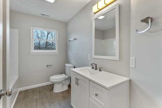 full bathroom featuring washtub / shower combination, hardwood / wood-style floors, vanity, and toilet