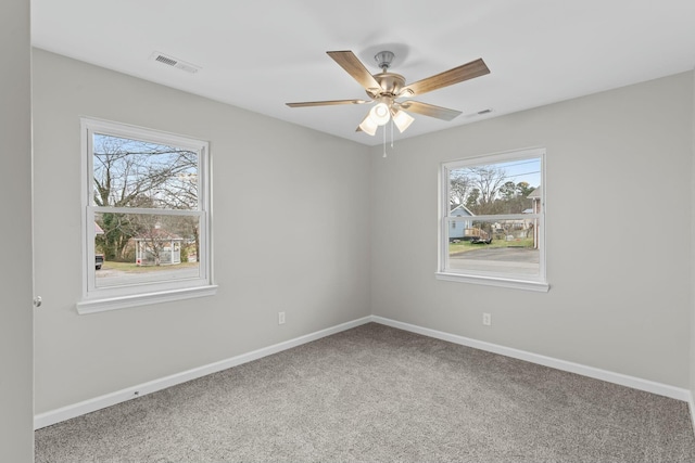 carpeted spare room with ceiling fan