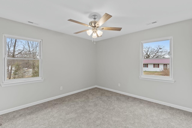 empty room featuring carpet flooring, ceiling fan, and plenty of natural light