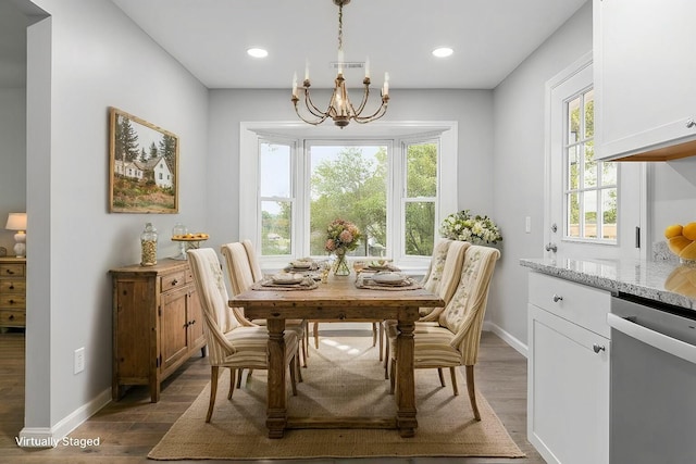 dining room with a notable chandelier, a healthy amount of sunlight, and dark wood-type flooring