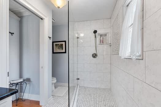 bathroom with a tile shower, vanity, and toilet