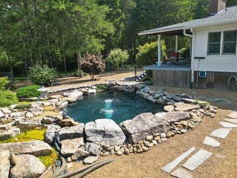 view of swimming pool with a small pond