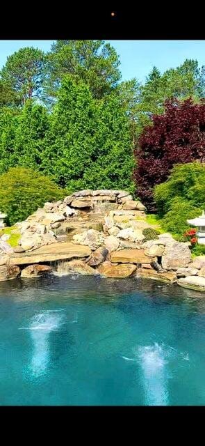 view of pool featuring a water view