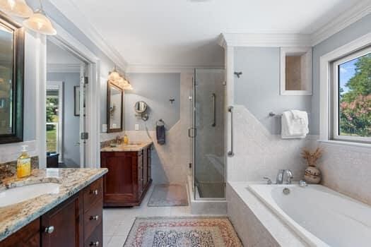 bathroom with tile patterned floors, crown molding, vanity, and plus walk in shower