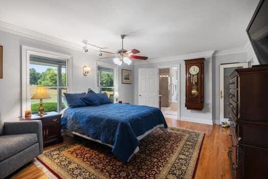 bedroom featuring hardwood / wood-style flooring, ceiling fan, and crown molding