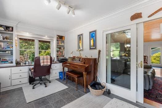 home office with built in desk and crown molding