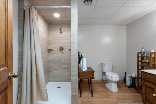 bathroom featuring walk in shower, toilet, vanity, and hardwood / wood-style flooring