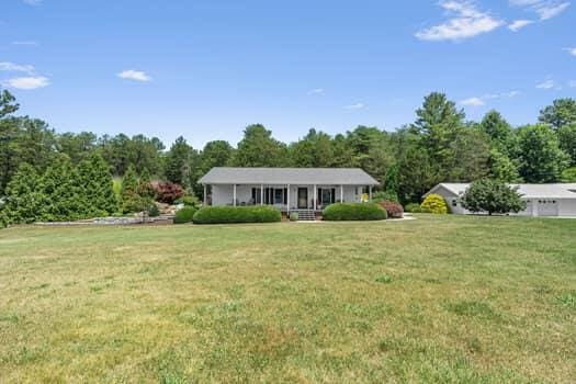 ranch-style house with a porch and a front yard