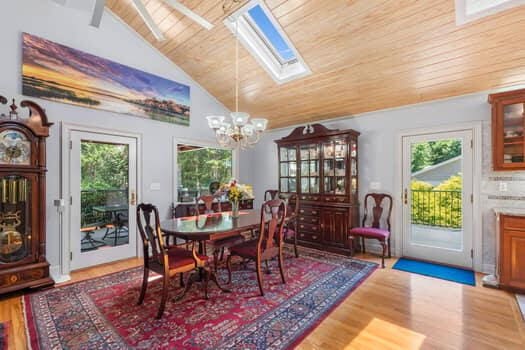 dining space featuring a skylight, plenty of natural light, wooden ceiling, and hardwood / wood-style flooring