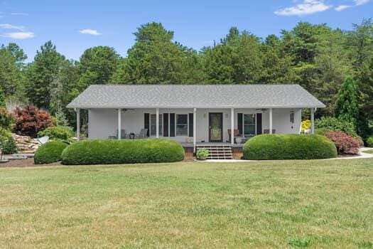 single story home with a front yard and covered porch