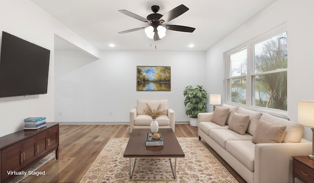 living room featuring ceiling fan and light hardwood / wood-style flooring