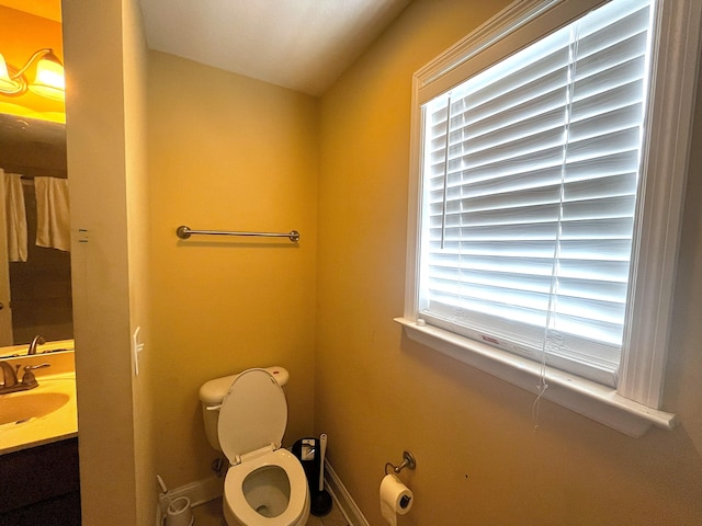bathroom featuring vanity, toilet, and baseboards