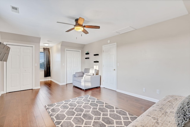 living area with ceiling fan and dark wood-type flooring