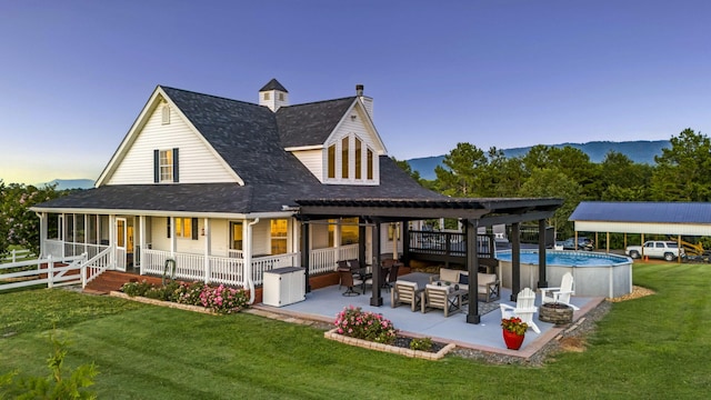 back of property with outdoor lounge area, a mountain view, and a lawn