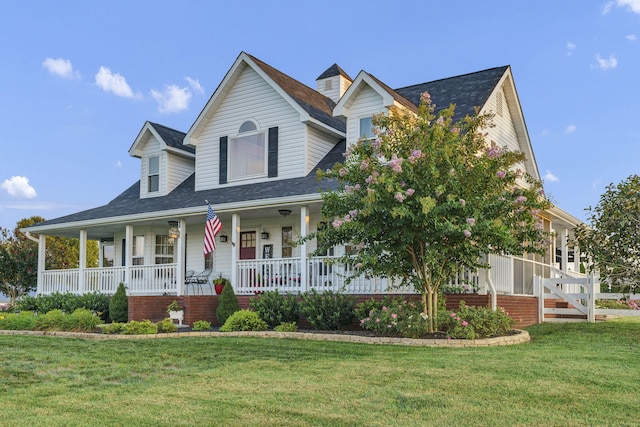 country-style home featuring covered porch and a front yard