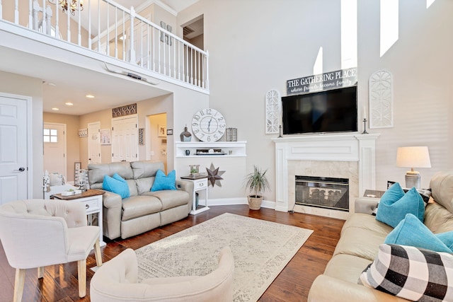 living room featuring a high end fireplace, dark hardwood / wood-style floors, and a high ceiling