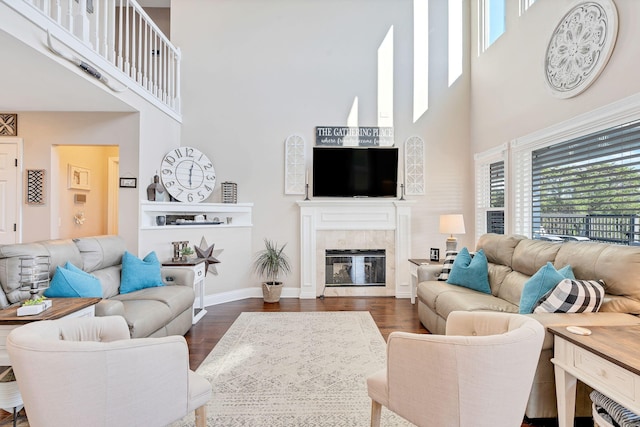 living room with dark hardwood / wood-style flooring and a towering ceiling