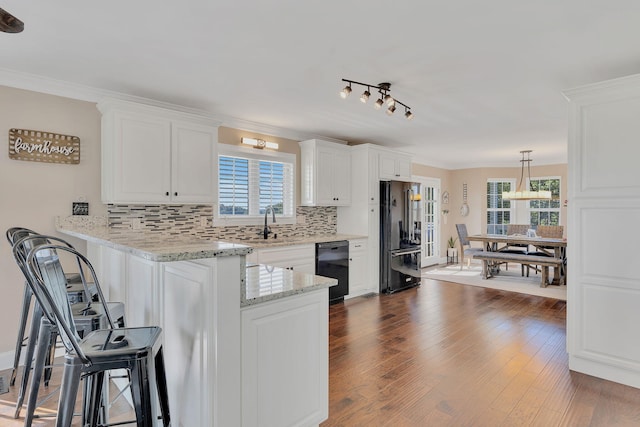 kitchen featuring kitchen peninsula, white cabinetry, and plenty of natural light