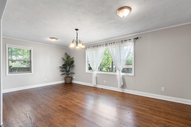 empty room with crown molding, dark wood-type flooring, a textured ceiling, and an inviting chandelier