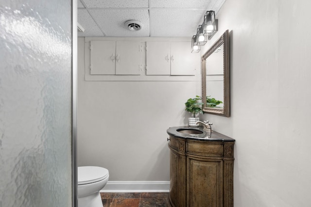 bathroom featuring vanity, toilet, and a paneled ceiling