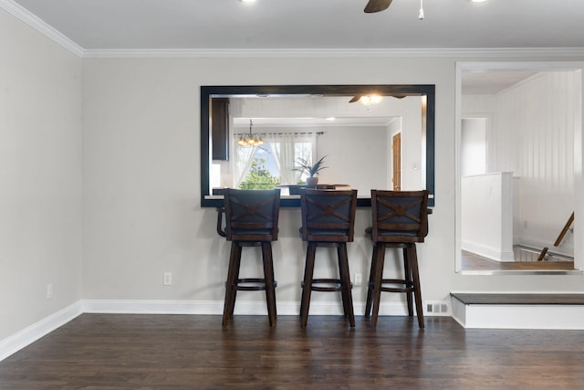 dining area featuring dark hardwood / wood-style floors, ornamental molding, and ceiling fan with notable chandelier