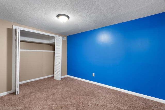 unfurnished bedroom with a closet, carpet, and a textured ceiling